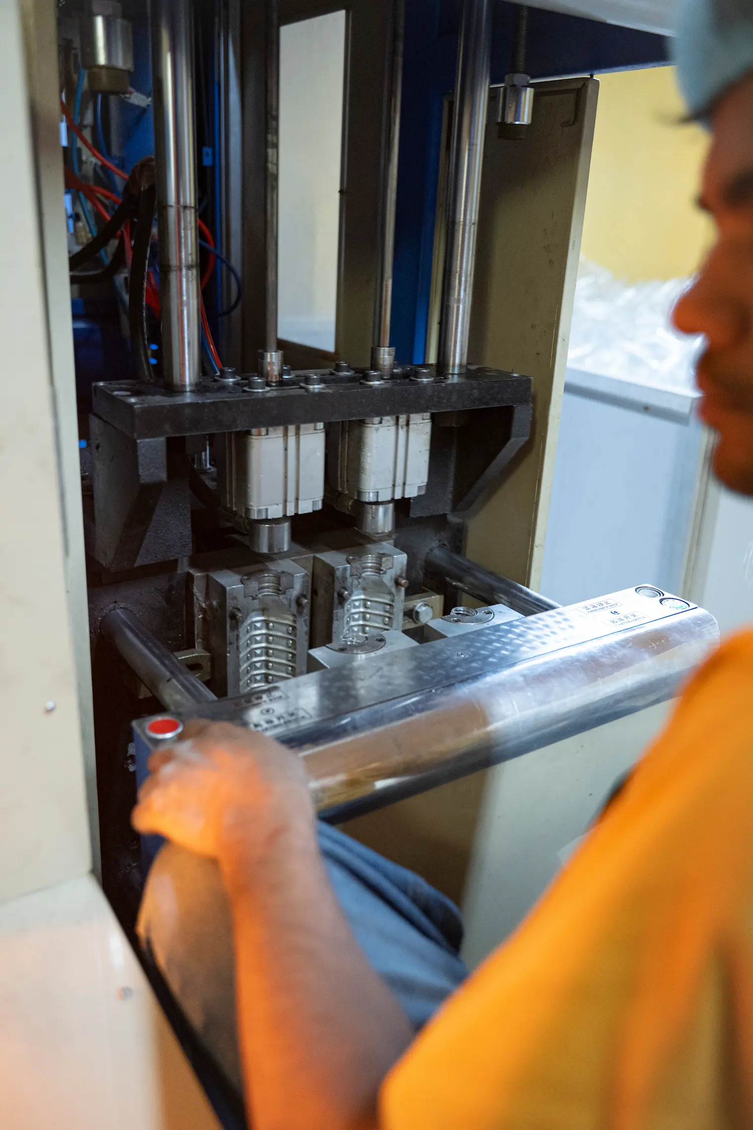 Machine shaping small plastic tubes into Khayul bottles